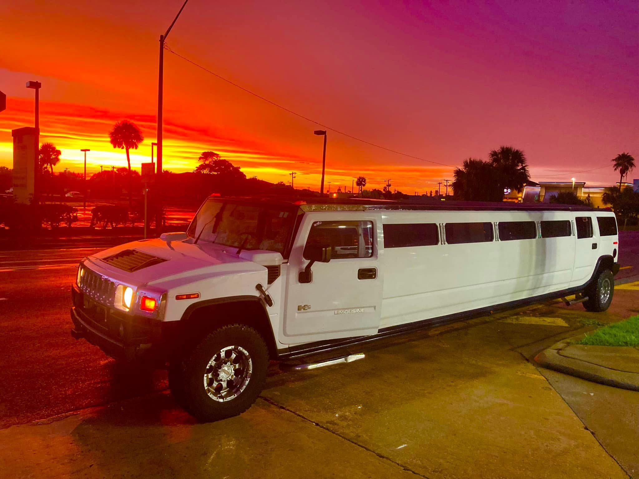 White Hummer H2 limousine at sunset